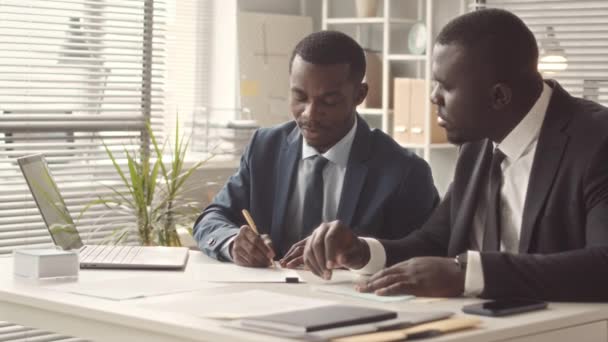 Двоє Молодих Добре Одягнених Афроамериканських Бізнесменів Обговорюють Бізнес Стратегії Сидячи — стокове відео