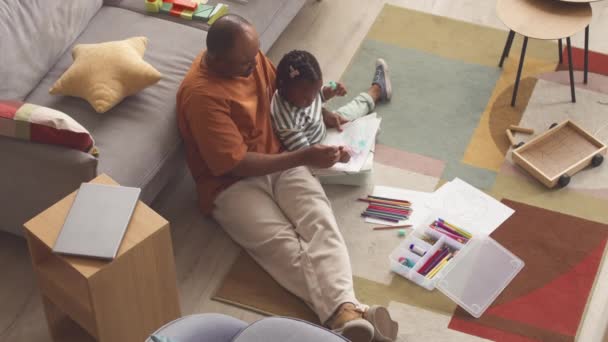 非洲裔美国人男人和他心爱的小女儿在家里聊天和画画 坐在客厅五彩缤纷的地毯上 — 图库视频影像