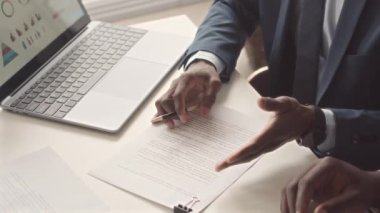 Ofis toplantısı sırasında imzalamadan önce iki klas siyahi işadamının sözleşmeyi birlikte okuması.