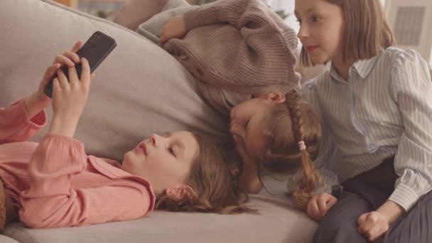 Tre Kaukasiske Elementære Skolepiger Tilbringer Tid Sammen Hjemme Hviler Sofaen – Stock-video