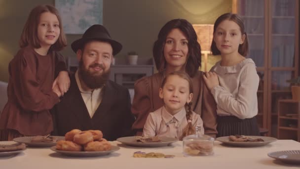 自宅でハヌカのお祝いの夕食をしながらカメラにポーズする5人の幸せなユダヤ人家族の肖像画 — ストック動画