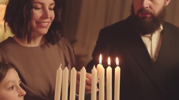 Еврейская Семья Трех Человек Собирается Вместе Зажечь Менору Свечи Хануке — стоковое видео