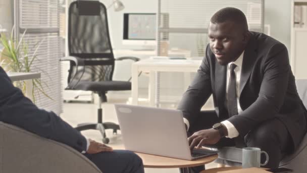 2人のアフリカ系アメリカ人の男性ビジネスパートナーが コンテンポラリーオフィスで会議中に会話と握手をしている — ストック動画