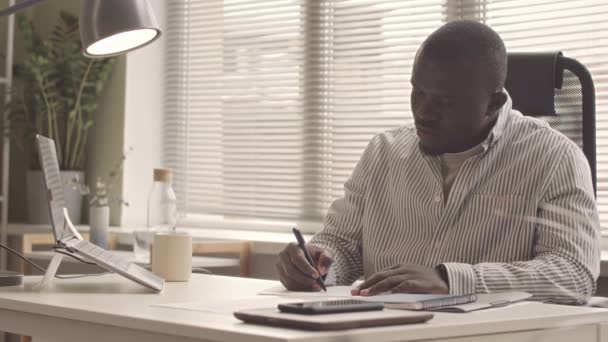 Σοβαρός Αφροαμερικανός Που Χρησιμοποιεί Φορητό Υπολογιστή Ενώ Εργάζεται Την Οικονομική — Αρχείο Βίντεο