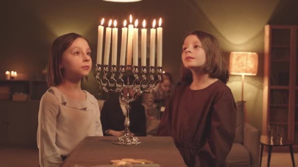 Две Младшие Сестры Смотрят Восемь Зажженных Свечей Меноры Время Семейного — стоковое видео