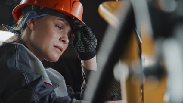 劳累的女机械师在修理拖拉机的同时擦干额头上的汗珠 在机械设备制造厂辛辛苦苦地工作 — 图库视频影像