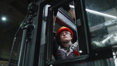 Profesyonel kadın teknisyen traktördeki kabloları bağlayan makine ekipman üretim tesisinde çalışıyor.