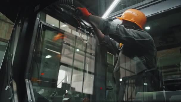 공장에서 일하는 트랙터 기계에 철사를 연결하는 직업적인 기술공 엔지니어 — 비디오