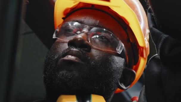 工业厂房机械设备施工时 用橙色硬礼帽连接电缆的聚焦非洲裔美国电工的闭锁 — 图库视频影像