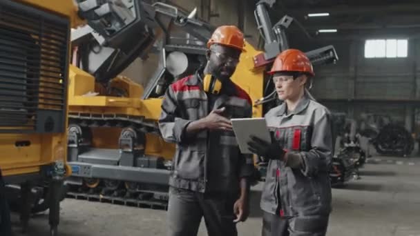 Two Multiethnic Male Female Engineers Hard Hats Coveralls Looking Tablet — Stock Video