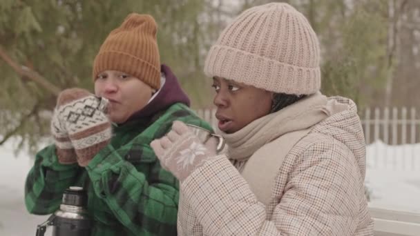 Glückliches Multiethnisches Lesbisches Paar Wärmt Sich Mit Heißem Tee Aus — Stockvideo