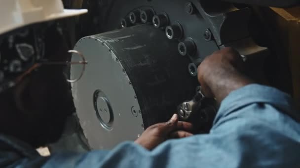 트랙터 플랜트에서 로더를 수리하는 렌치를 사용하여 모자에있는 기계학자의 — 비디오