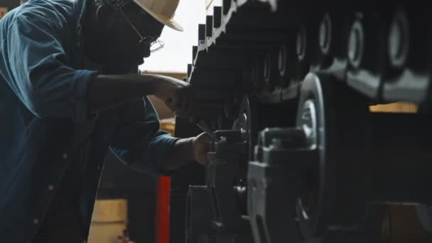 室内安装拖拉机时使用扳手的牛仔衬衫和硬帽子的黑人男性服务技师 — 图库视频影像