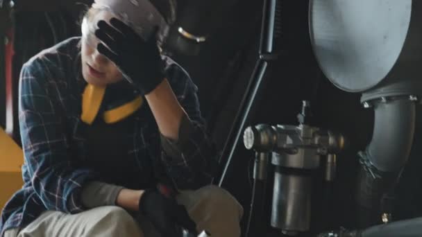 在室内修理拖拉机时 努力工作的年轻女机械师用螺栓扳手 — 图库视频影像