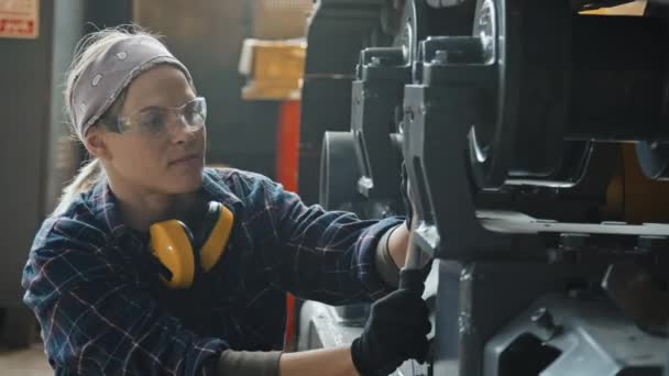 车间牵引机固定轮时使用螺栓扳手的安全眼镜女服务员 — 图库视频影像
