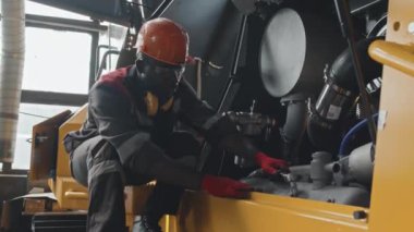 Sert şapkalı siyah erkek tamirci ve servis merkezinde ingiliz anahtarı cıvatalı boru tamircisi.