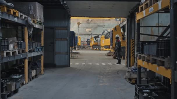 Повільна Темношкіра Людина Капелюсі Капелюсі Йде Вздовж Тракторного Машинобудівного Заводу — стокове відео