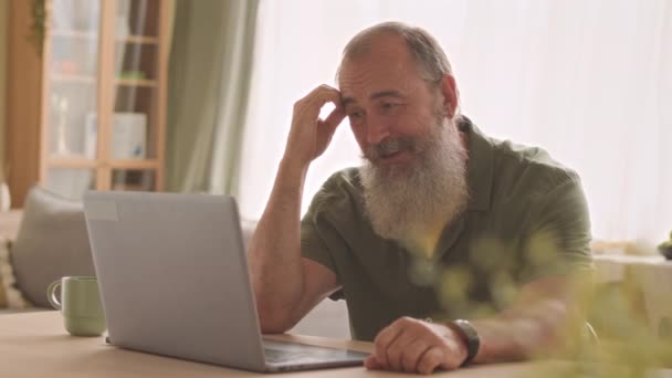 快乐的白胡子老人在家里的笔记本电脑上与家人聊天 — 图库视频影像