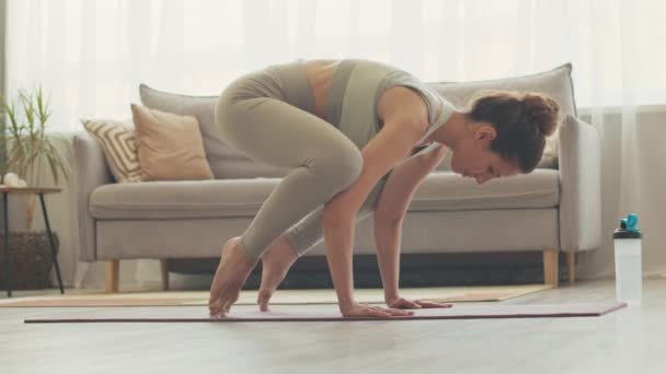 Junge Aktive Frau Steht Krähenpose Während Sie Hause Yoga Praktiziert — Stockvideo
