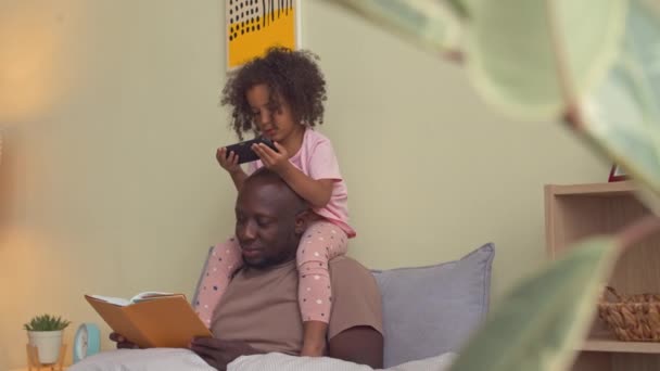 Nettes Afroamerikanisches Mädchen Sitzt Auf Papas Schultern Und Schaut Cartoons — Stockvideo