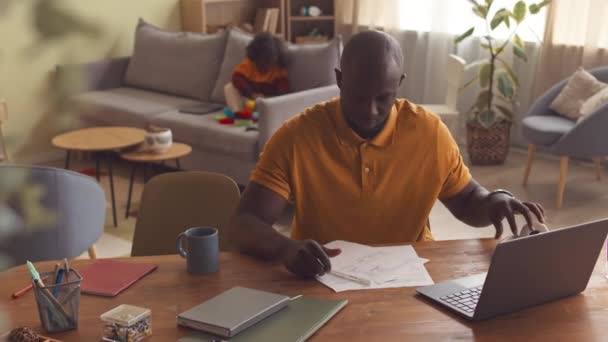 African American Man Putting Wireless Headphones Work Laptop Home Office — Stock Video