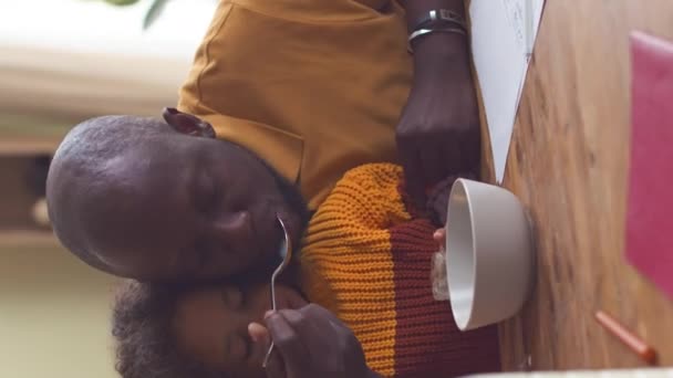 Tiro Vertical Homem Negro Alimentando Sua Filhinha Com Cereais Leite — Vídeo de Stock