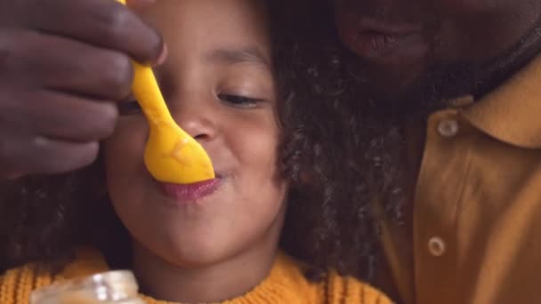 Close African American Man Feeding His Pretty Little Daughter Baby — Stock Video