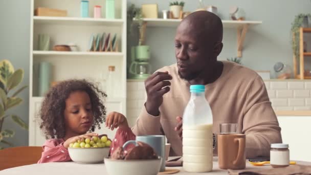 美国黑人父亲和他3岁的女儿一起在舒适的厨房里吃早餐 — 图库视频影像