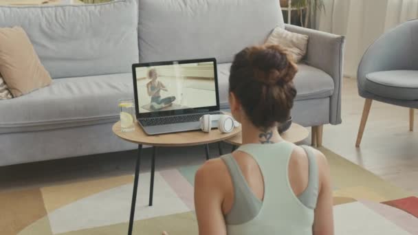 女子瑜伽教练脖子上有象形文字纹身 通过笔记本电脑进行在线视频练习的背景图 — 图库视频影像