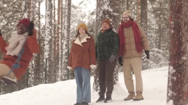 Ung Svart Man Svänger Vacker Snöig Tallskog Medan Tillbringa Vintern — Stockvideo