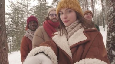 Kışın ormanda bir grup arkadaşıyla vakit geçirdiği videoyu kaydeden güzel, beyaz bir kadının el bilgisayarı yavaşlığı.