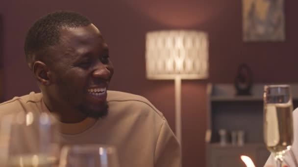 Wesoły Afroamerykanin Uśmiecha Się Podczas Rozmowy Przyjaciółmi Kolacji Brzęczy Kieliszkami — Wideo stockowe