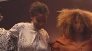 Bir grup neşeli genç, partide birlikte enerjik bir şekilde dans ediyorlar.