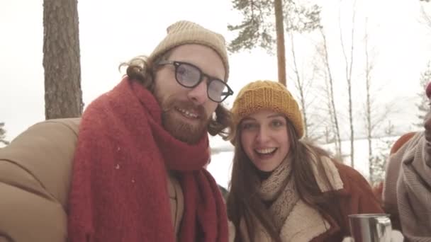 冬の森で1日外で過ごすビデオを録画する4人の多民族友人のハンドヘルドPovショット — ストック動画