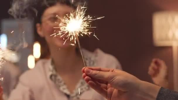 年轻快乐的女人和她快乐的朋友们在家里庆祝圣诞节的时候手握火花 — 图库视频影像