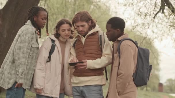 Baharda Parkta Birlikte Yürürken Akıllı Telefondan Haritaya Bakan Çeşitli Arkadaşlar — Stok video