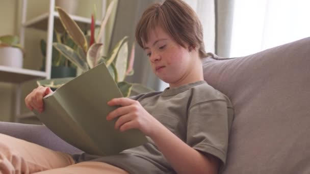 Konzentriertes Mädchen Mit Syndrom Liest Der Freizeit Hause Buch — Stockvideo