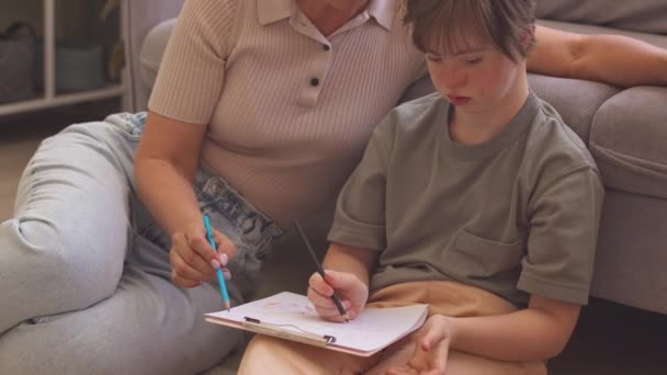 Menina Concentrada Com Síndrome Sua Mãe Carinhosa Sentados Juntos Sala — Vídeo de Stock