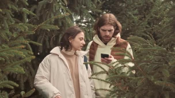 Genç Beyaz Çift Ilkbaharda Köknar Ağaçlarının Arasında Akıllı Telefondaki Navigasyon — Stok video