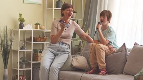 有才华的14岁患有唐氏综合征的女孩在家里和妈妈一起用麦克风唱歌 — 图库视频影像
