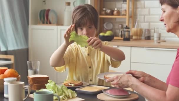 Moeder Haar Tienerdochter Met Dons Syndroom Zelfgemaakte Sandwiches Samen Keuken — Stockvideo