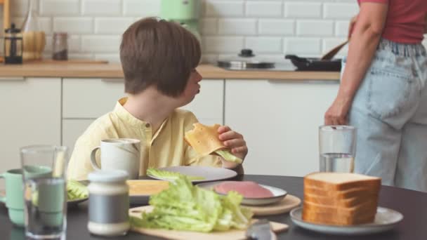 Kaukasisches Teenager Mädchen Mit Syndrom Frühstückt Küchentisch Mit Sandwich Während — Stockvideo
