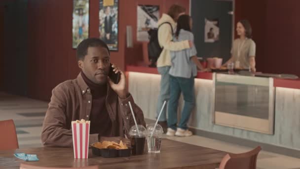 Ung Afroamerikansk Man Pratar Smartphone Medan Väntar Film Bio Interracial — Stockvideo