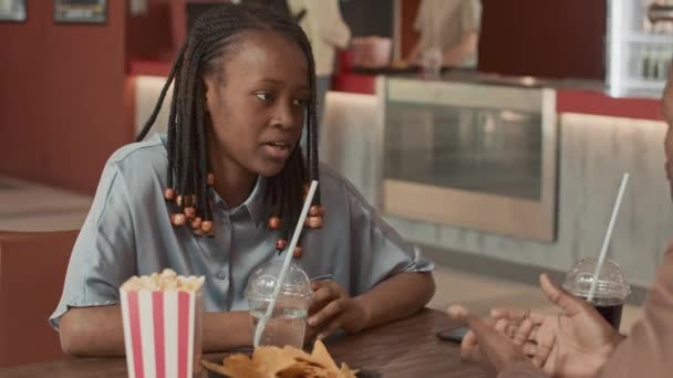 Csinos Afro Amerikai Lány Asztalnál Moziban Barátjával Kéz Kézben Vár — Stock videók