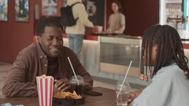 Молода Афроамериканська Пара Сидить Столом Кінотеатрі Розмовляючи Очікуванні Фільму — стокове відео