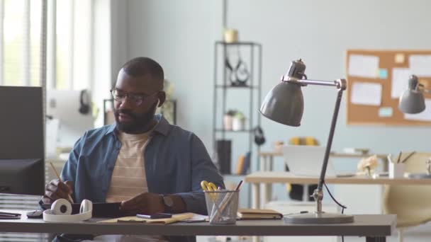Pan Ujęcie Afroamerykańskiego Biznesmena Omawiającego Szczegóły Projektu Zespołem Słuchawkach Bezprzewodowych — Wideo stockowe