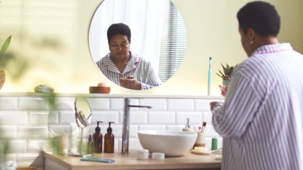 African American Woman Striped Pajamas Applying Nourishing Cream Her Face — Stock Video