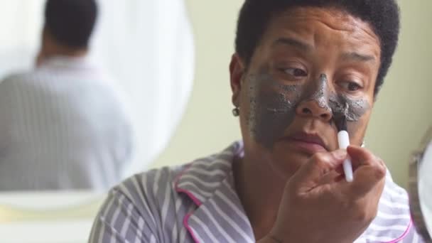 Ώριμη Μαύρη Γυναίκα Ριγέ Πιτζάμες Που Εφαρμόζει Μάσκα Προσώπου Από — Αρχείο Βίντεο