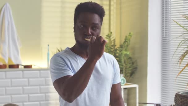 Genç Siyah Adam Sabah Banyoda Dişlerini Fırçalarken Aynaya Bakıyor — Stok video