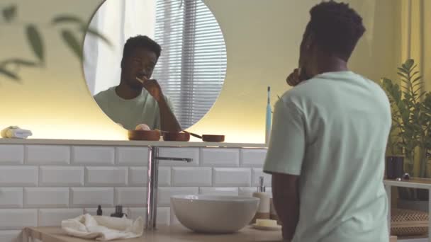 Widok Tyłu Afroamerykanina Patrzącego Lustro Podczas Mycia Zębów Rano — Wideo stockowe